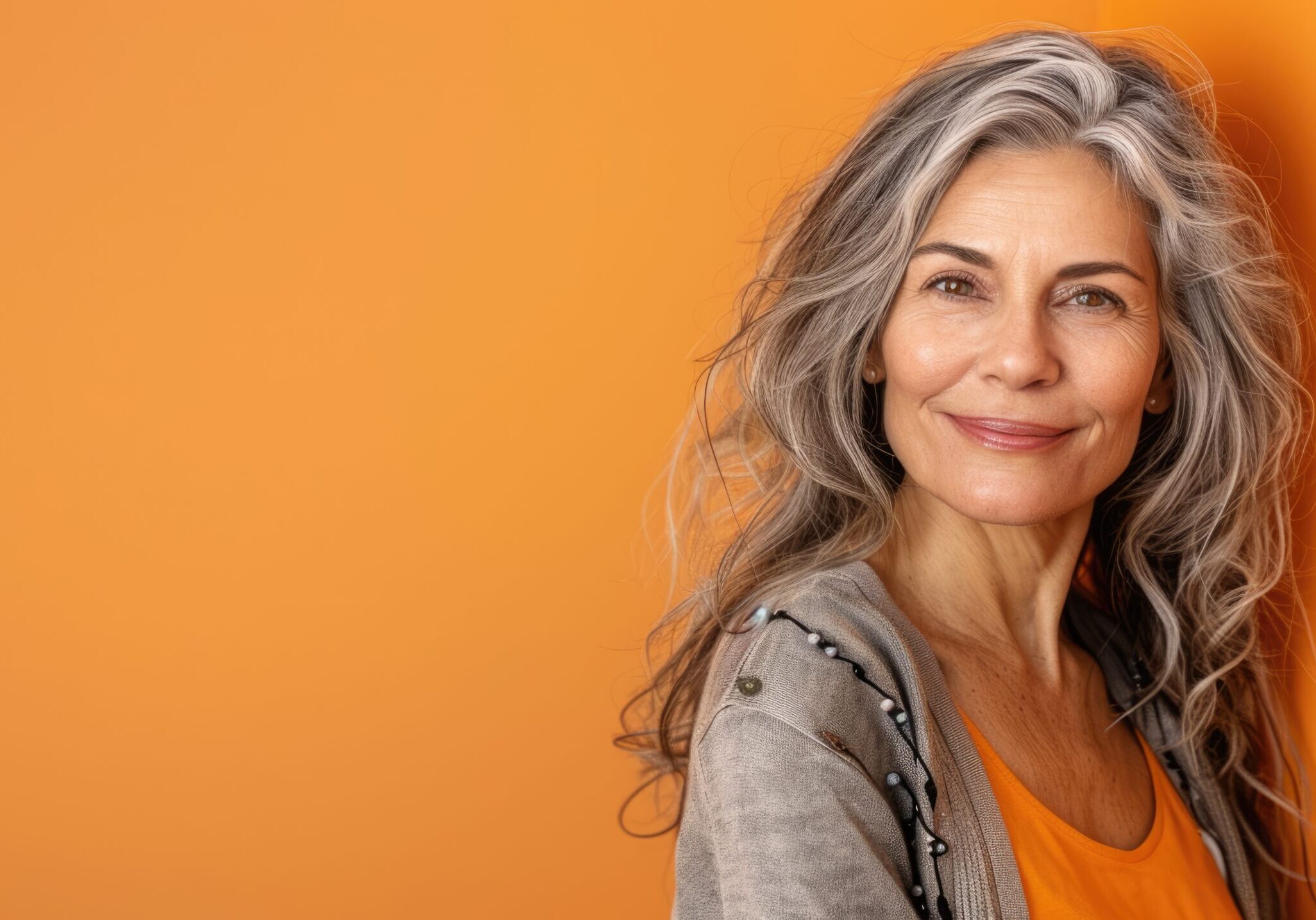 A woman with long gray hair poses for the camera.