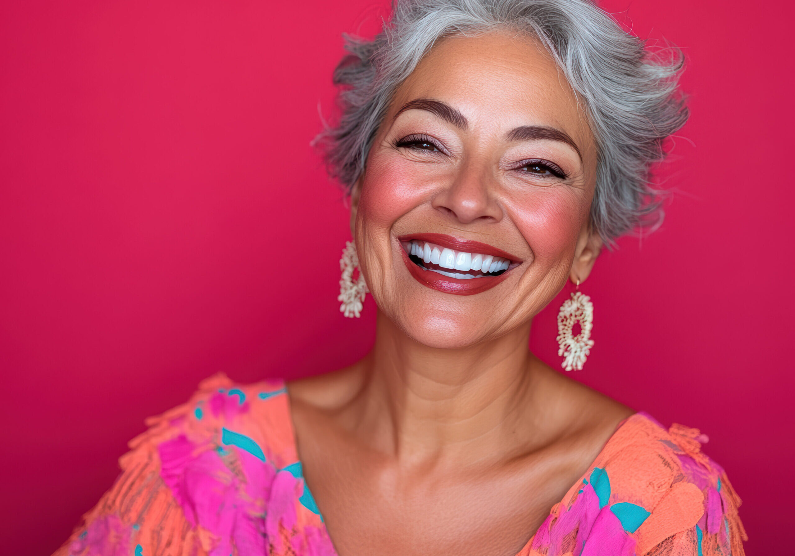 A woman with grey hair smiling for the camera.